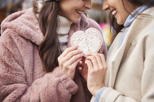 Les femmes liées à un biscuit de pain d'épice en forme de coeur  - Photo, image
