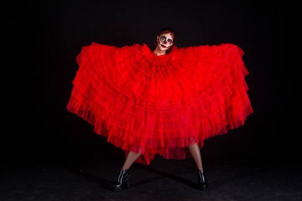 красивая женщина в красном платье танцует на черном фоне студии - Фото, изображение