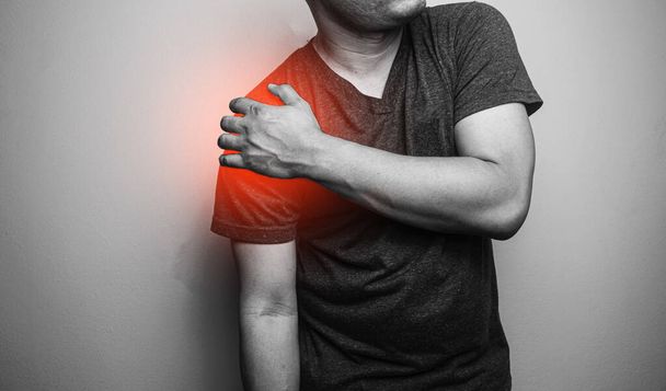 Close up Shoulder pain in a man, Young man holding his shoulder in pain  Shoulder inflammation symptoms medical healthcare concept - Valokuva, kuva