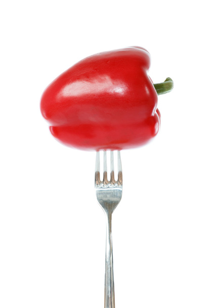 Pimiento rojo entero clavado en un tenedor
 - Foto, imagen