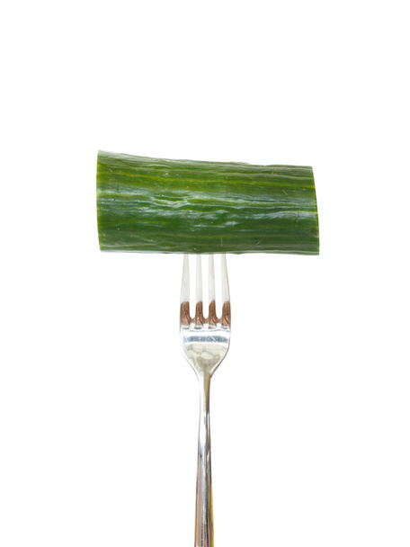 Gran trozo de pepino clavado en un tenedor
 - Foto, Imagen