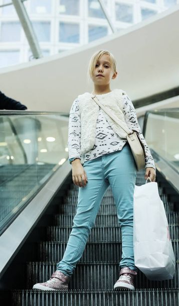 Fashion 9 years old girl with packages in shopping center - Φωτογραφία, εικόνα