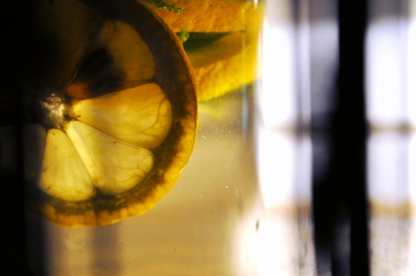 tranche de citron dans l'eau lumière brillante à travers la silhouette santé des fruits - Photo, image