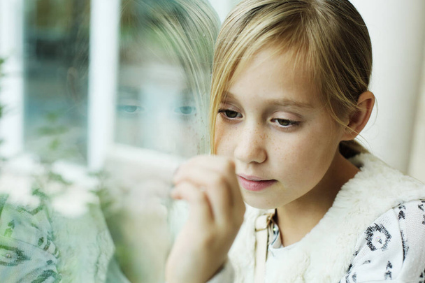 Young girl looking through the window. Quarentine concept - Photo, Image