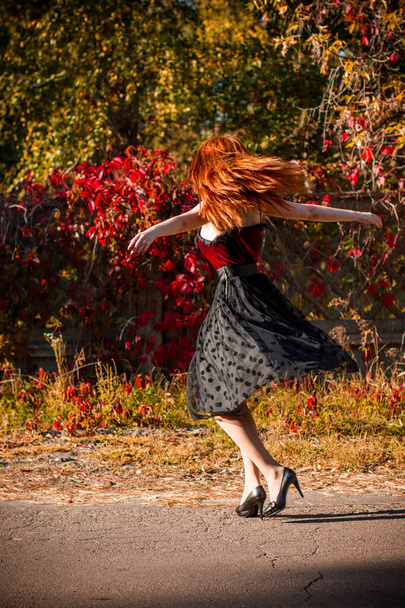 Herbsttrend, stylisch gekleidetes Mädchen. Frauenporträt in Vintage-Tönen. Dame mit rotem Haar im Samthemd und gepunktetem Rock - Foto, Bild