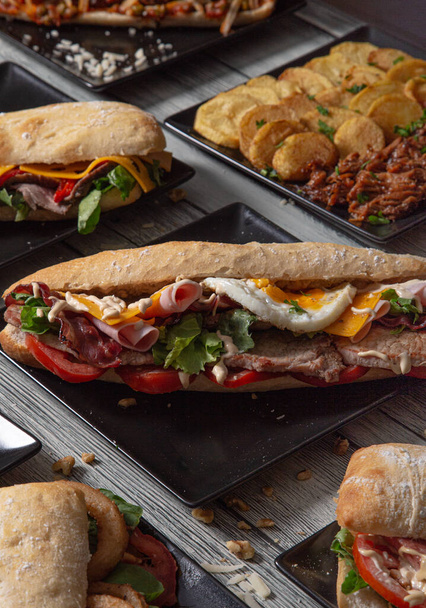 Různé sendviče na dřevěném stole. A la carte restaurant. Středomořské potraviny - Fotografie, Obrázek
