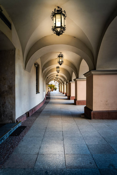 Arkaden oder Torbögen mit langem Korridor, beleuchtet von historischen Laternen. Rathausgebäude am Stadtplatz in Kielce, Polen - Foto, Bild