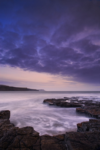 Bela paisagem de paisagem marinha tonificada de costa rochosa ao pôr do sol
 - Foto, Imagem