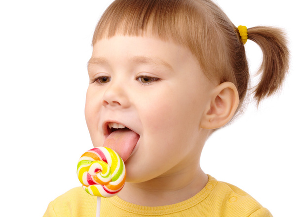 Little girl with lollipop - Фото, изображение