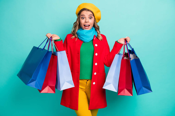 Astonished crazy girl impressed 50 off-sales buy all shopping center show bags scream wow omg wear red green blue yellow sweater pants trousers headwear isolated teal color background - Photo, image