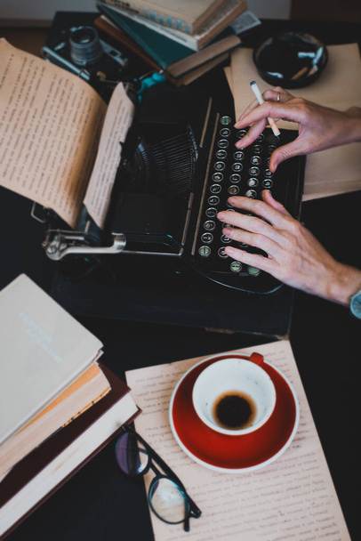 a beautiful old retro typewriter close-up, hands and a cup of coffe - Фото, зображення
