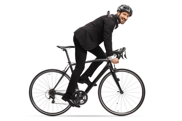Profile shot of a man in a suit riding a bicycle to work isolated on white background - Foto, Imagem
