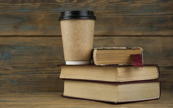 Books and disposable cup on wooden surface  - Foto, immagini