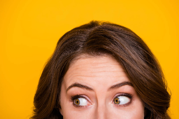 Closeup cropped facial expression photo of funny terrified lady look half face scared big eyes side empty space isolated bright yellow color background - Foto, afbeelding