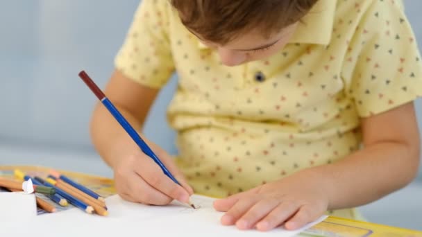 μικρό χαριτωμένο αγόρι ζωγραφίζει με μολύβια. το παιδί ασχολείται με τη δημιουργικότητα στο σπίτι - Πλάνα, βίντεο