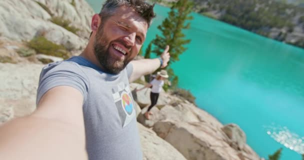 Gölde mutlu romantik bir çift. Neşeli adam manzaralı mavi göl 4K 'de selfie çekiyor. - Video, Çekim