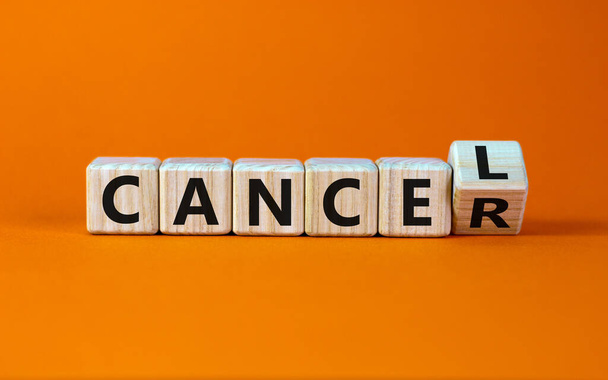 Symbol for stopping cancer. Turned a cube and changed the word 'cancer' to 'cancel'. Beautiful orange background. Business concept. Copy space. - Foto, immagini