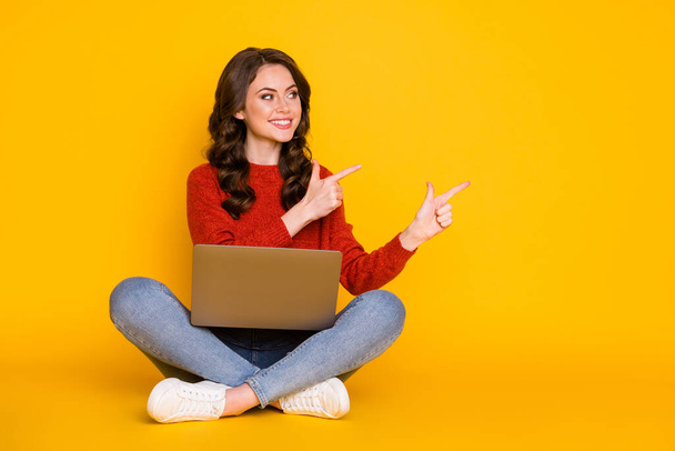 Portrait of her she nice attractive cheerful cheery wavy-haired girl sitting using laptop showing idea copy space advert isolated on bright vivid shine vibrant yellow color background - Foto, afbeelding