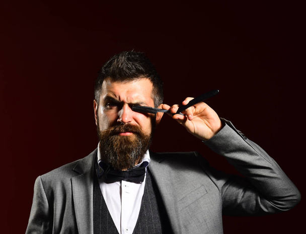 Macho in formal suit shaves beard. Man with long beard - Foto, imagen