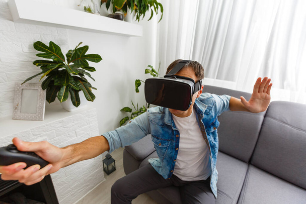 Junger Mann spielt Spiele mit Virtual-Reality-Brille - Foto, Bild