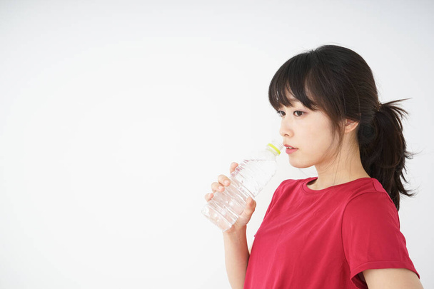 Jonge vrouw blijft gehydrateerd tijdens de sport - Foto, afbeelding