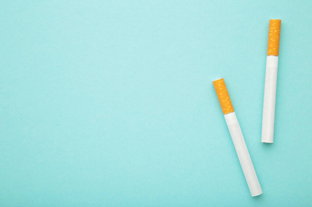 Two cigarettes on a blue background. Top view. - Foto, afbeelding
