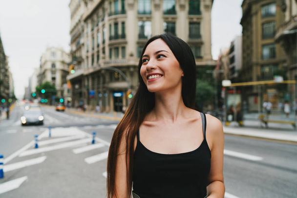 Young beautiful caucasian model look woman wearing trendy clothes posing to the camera while standing on a city road background. Stylish Tourist girl enjoying walking the city during weekend trip.  - Foto, imagen