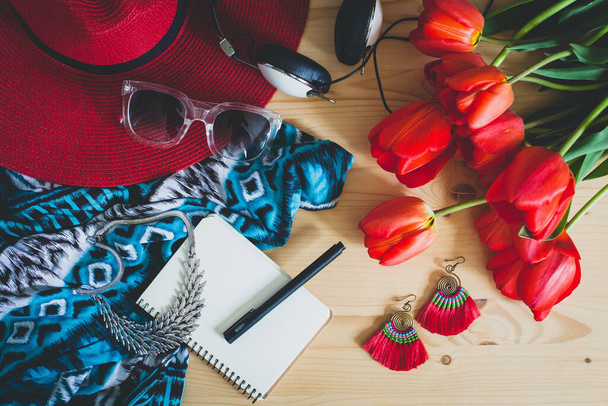 woman's accessories, red tulips, sunglasses, hat, headphones, scarf, necklace, earrings, spring fashion trend, view from above, details, vintage bohemian style, notebook, pen, diary - Foto, Bild