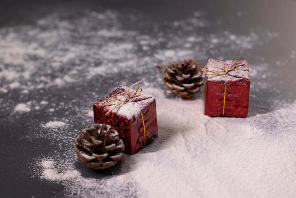 Joulukoristeet lumessa - lahjat ja käpyjä. Joulun tunnelma - Valokuva, kuva
