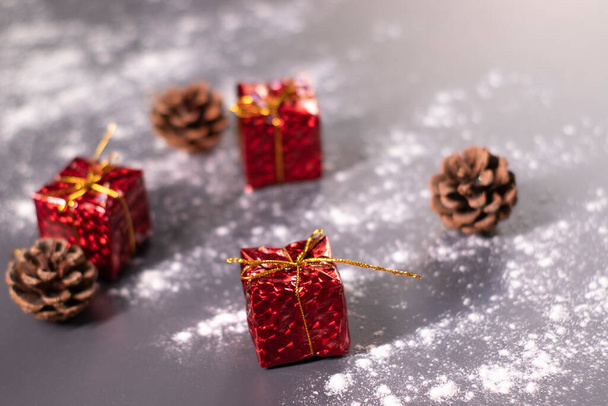 Świąteczne dekoracje w śniegu - prezenty i szyszki. Świąteczny nastrój - Zdjęcie, obraz