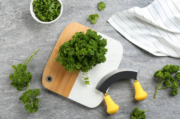 Fresh curly parsley, cutting board and mincing knife on grey table, flat lay - Foto, afbeelding