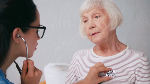 jeune gériatre examinant un patient âgé avec stéthoscope - Séquence, vidéo