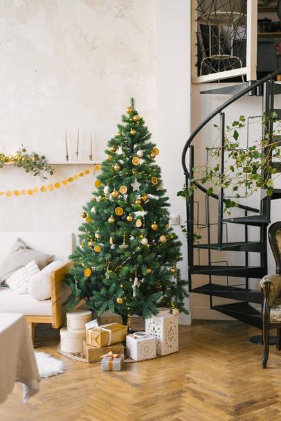 Karácsonyfa díszített játékok, szárított citrom vagy narancs, koszorúk a nappaliban. Skandináv karácsonyi stílus a házban - Fotó, kép