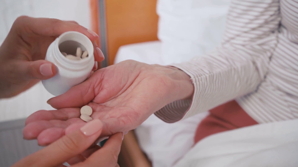 visão cortada do médico dando pílulas para o paciente em casa de repouso - Filmagem, Vídeo