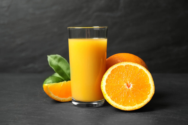 Glass of orange juice and fresh fruits on grey table - Fotoğraf, Görsel
