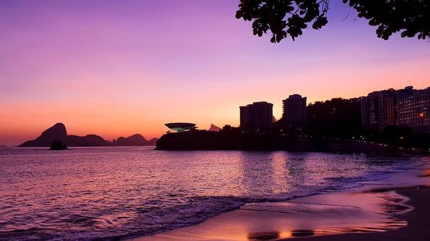 Por do Sol na orla de Niteroi, Rio de Janeiro - Brasile. Nessa imagem e possivel ver o Pao de Acucar e o Museu de Arte Contemporanea uma beleza natural e outra criada por Oscar Niemeyer - Foto, immagini
