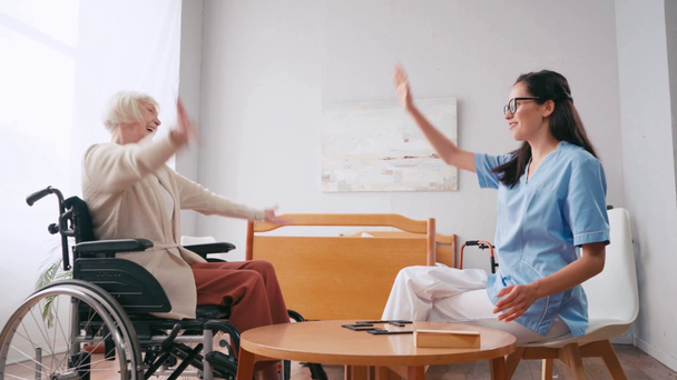Neşeli engelli kadın ve hemşire domino oynarken beşlik çakıyor - Video, Çekim
