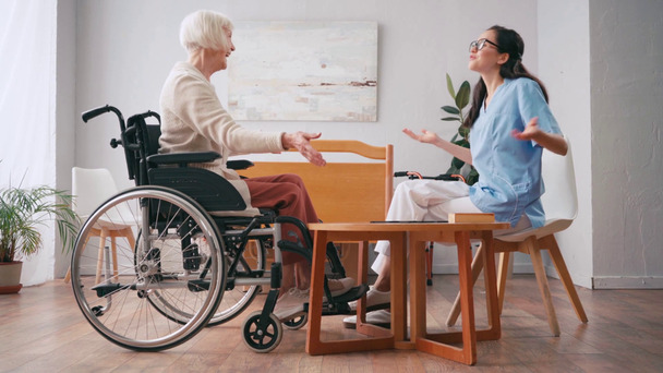 nuori sairaanhoitaja ja vanhempi nainen kättelee pelatessaan lautapeliä - Materiaali, video