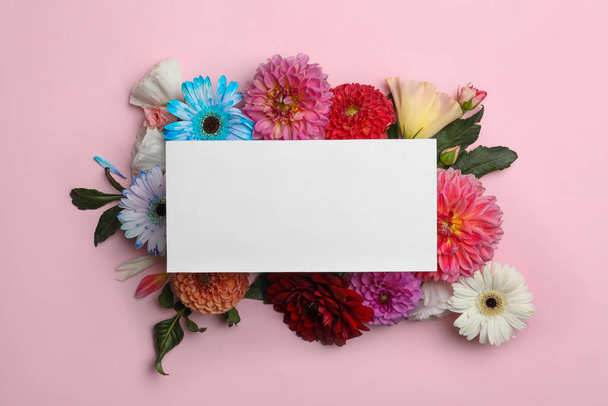 Flat lay composition with blank card, dahlia and gerbera flowers on pink background. Space for text - 写真・画像