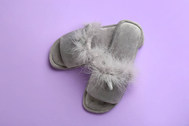 Pair of stylish soft slippers on violet background, flat lay - Фото, изображение