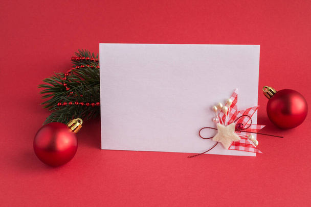 Nahaufnahme auf weißem Papier für Weihnachtsgrüße auf rotem Hintergrund - Foto, Bild