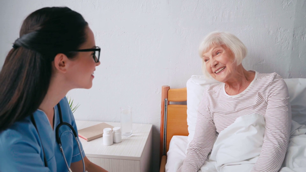 mosolygó idős nő beszél idős orvos az idősek otthonában - Felvétel, videó