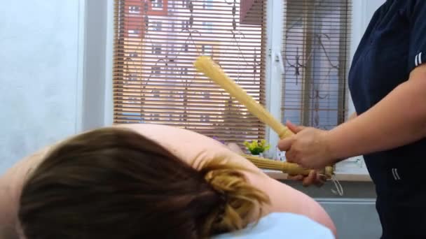 масажист робить антицелюлітний масаж товстих жіночих ніг з бамбуковими паличками. Лікар робить процедури для поліпшення стану шкіри. Агресивна боротьба з жиром. Спа лікування
. - Кадри, відео