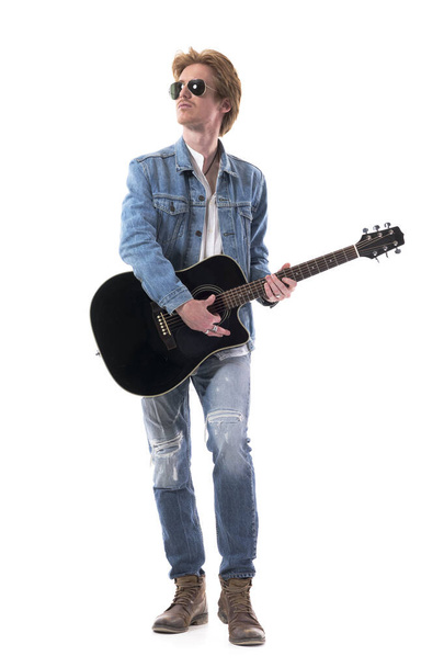 Красивый молодой человек-гитарист, играющий на акустической гитаре. Полное тело изолировано на белом фоне. - Фото, изображение