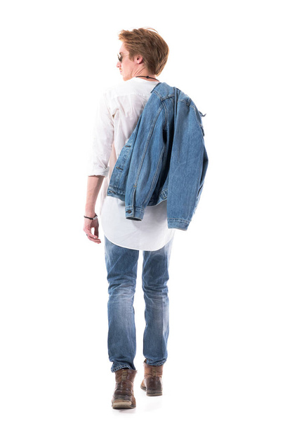 Visão traseira de homem elegante confiante em jeans andando e olhando para o lado. Corpo inteiro isolado em fundo branco. - Foto, Imagem