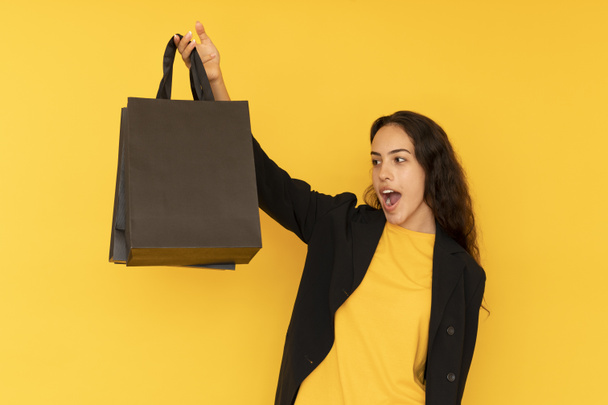 Černá páteční žena s nákupní taškou z černého papíru. Kopírovat mezerník na tašce - Fotografie, Obrázek