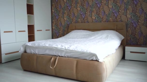 przytulny pokój z dużym łóżkiem i szafą - Materiał filmowy, wideo