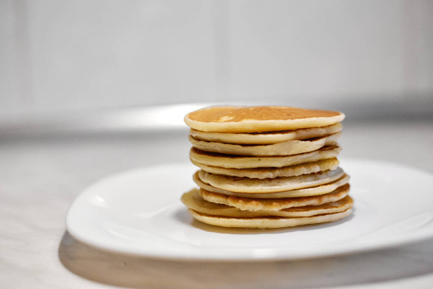 A stack of pancakes is on a white plate, Pancakes on a white plate top view, Pancakes on a white plate, - Foto, afbeelding