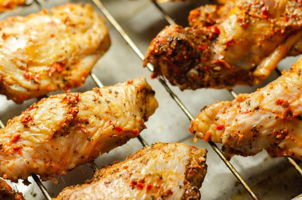Ailes de poulet cru avec un frottement de style rendang fait de piment et d'ail sur le plateau de grill, nourriture asiatique - Photo, image