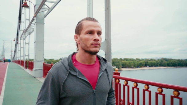Gericht sportman loopt op brug pad met natuur landschap op de achtergrond - Video